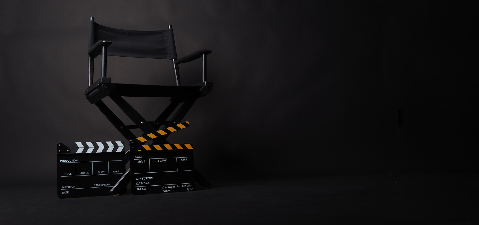 Director's Chair and Clapperboards on Black Background